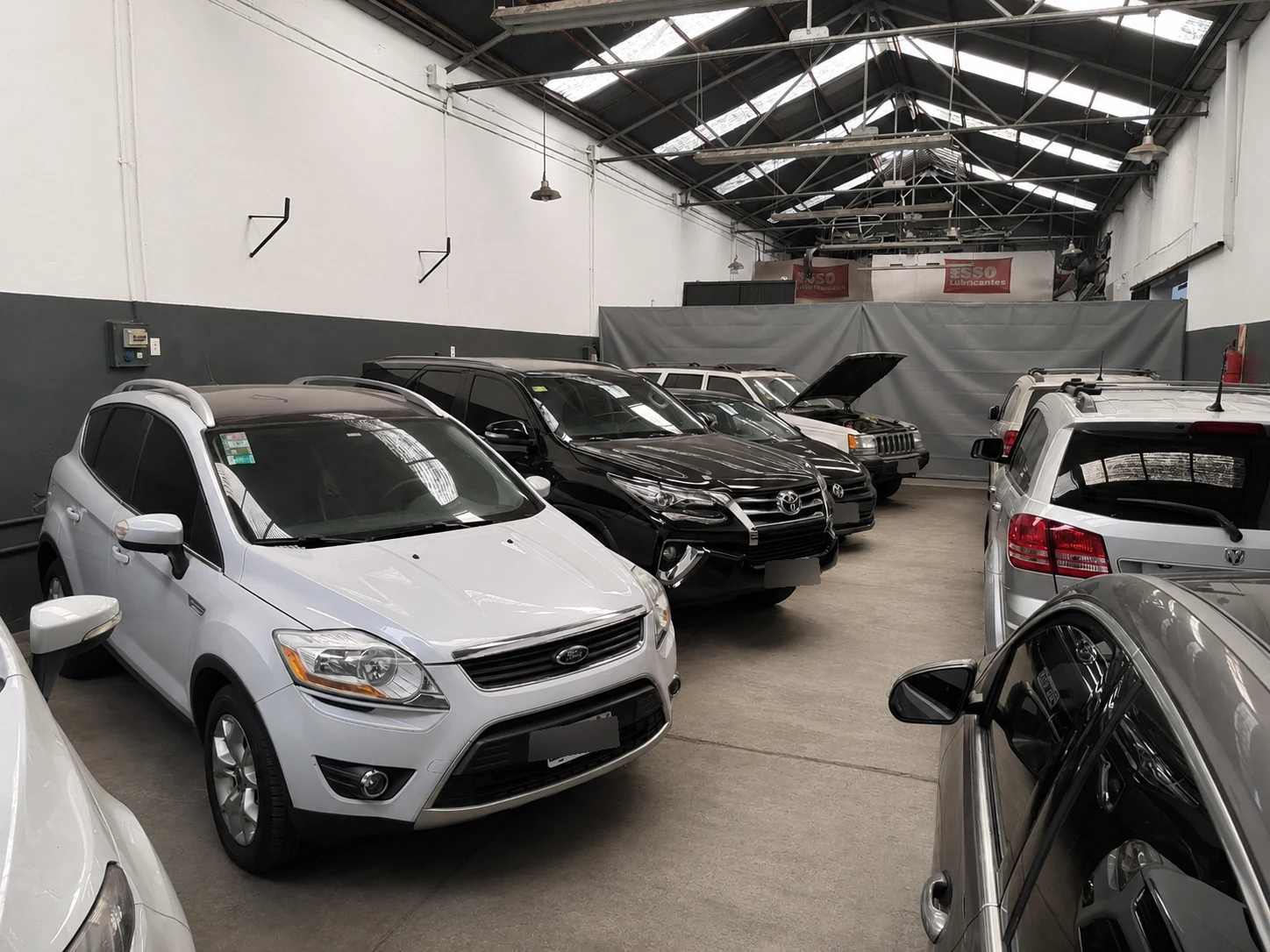 Vehículos de distintas marcas (Ford, Toyota, Jeep y Dodge) en el taller mecánico multimarca Lomayler en Villa Crespo, CABA