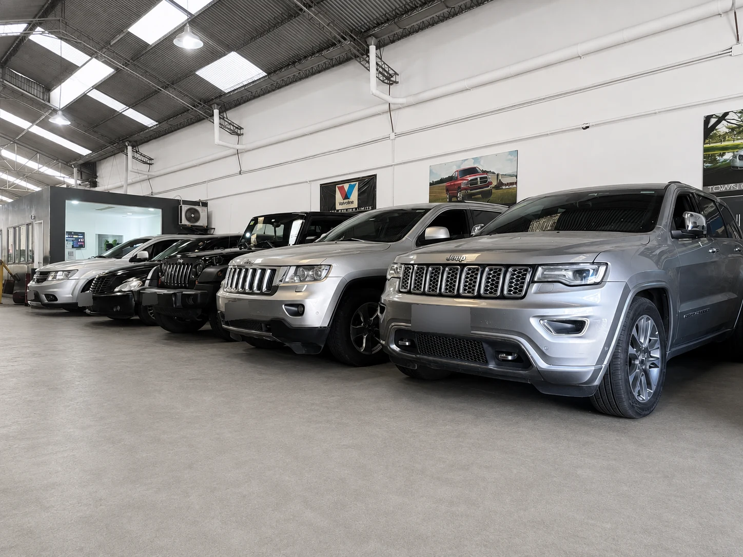 Fila de vehículos Jeep Grand Cherokee, Chrysler y Dodge en el taller multimarca Lomayler en Villa Crespo, CABA